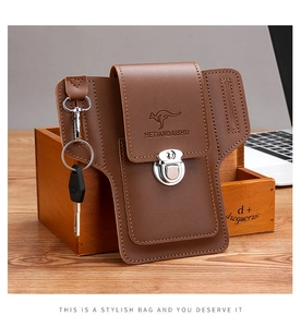 Detail view of brown leather belt pouch with metal buckle and functional key ring hook