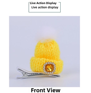 Detail of yellow knitted Christmas hat hair clip with a rhinestone gem and white pom-pom