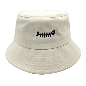 Detail of fish bone embroidery on cream cotton bucket hat with blue eye accent