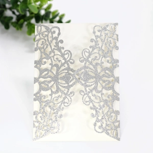 Detail of silver glitter laser-cut invitation sleeve with elegant baroque patterns
