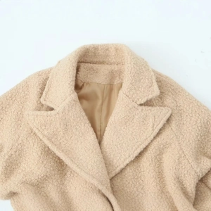 Beige shearling long coat for women with stylish wide lapel collar detail and soft woolly texture