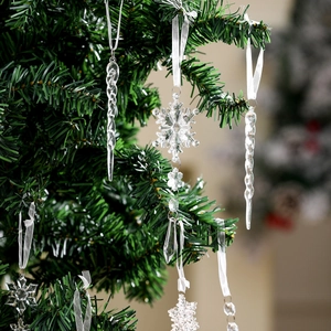 Close-up of transparent acrylic snowflakes and icicles hanging on a lush green Christmas tree