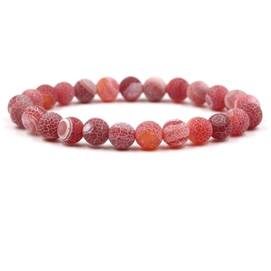 Macro detail of red frosted dragon vein agate beads on a stretch bracelet with a white background