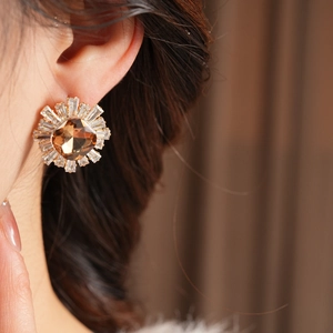 Détail de boucles d'oreilles vintage en forme de tournesol avec pierre ambrée