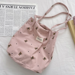 Detail of pink corduroy tote bag featuring bear print and Suzakka canvas studio label