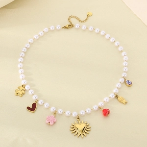 Colorful pearl necklace with gold fish, heart and flower charms on a warm beige background