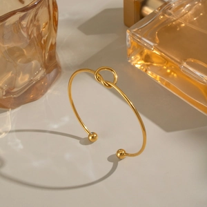 Dettaglio di un bracciale a nodo minimalista in acciaio inossidabile placcato oro 18K