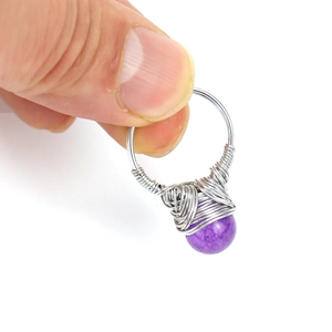Close-up of handmade silver wire wrapped ring featuring a 10mm round purple amethyst bead