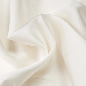 Close-up macro view of the premium smooth white satin fabric with elegant drape and luster