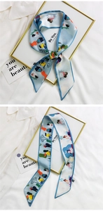 Detail of light blue satin hair ribbon with cartoon illustration and elegant quote