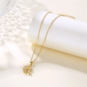 18K gold leaf necklace with sparkling zircon pendant on minimalist white pedestal