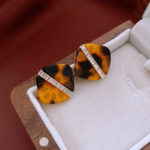 Macro shot of tortoise shell resin stud earrings with crystals on a jewelry box