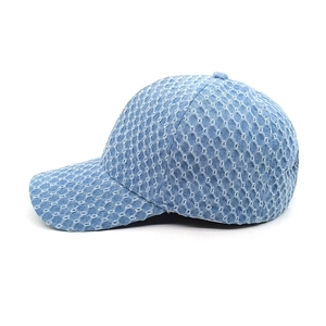 Detail of blue washed denim baseball cap with distressed textures and breathable mesh design