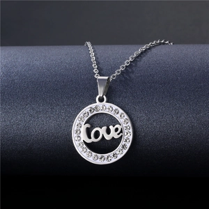 Detail of silver hollow circle pendant with Love engraving and sparkling rhinestones