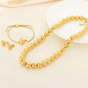 Close-up of golden stainless steel hollow bead necklace, bracelet and earrings jewelry set