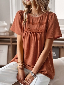Detail view of the round neck top with textured polka dots and crochet lace trim