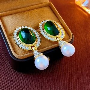 Vintage style gold earrings with green oval gemstone and white pearl in velvet jewelry box