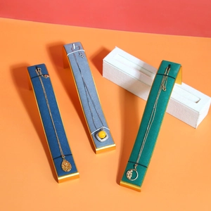Curved microfiber jewelry display stands for necklaces in blue, grey, and green colors