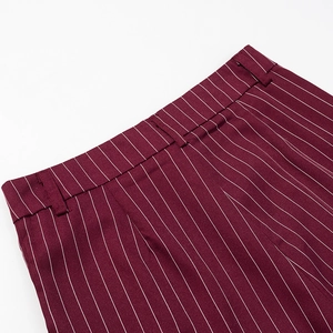Detailed close-up of burgundy pinstripe trousers waistband with precise stitching