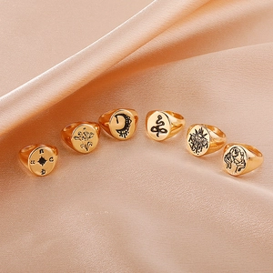Set of six gold vintage rings featuring sun and moon engravings on champagne satin fabric