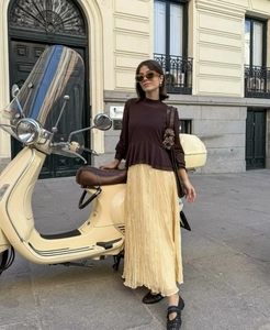 Close-up of pleated yellow skirt fabric and brown top with ruffles in outdoor setting