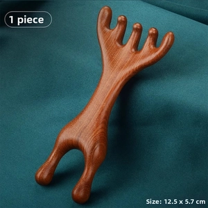 Detail of sandalwood head massager 12.5x5.7cm on silk, showing natural wood grain texture