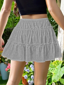 Back view of gray tiered cake skirt with elastic high waist in outdoor natural setting