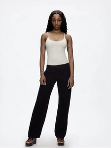 Front full view of white U-neck slim fit crop tank top with black trousers and sandals