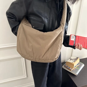 Khaki nylon sponge tote bag worn by a model in a black leather jacket for casual style