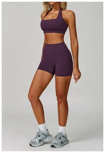 Detail of dark purple yoga set featuring a halter neck sports bra and high waist shorts