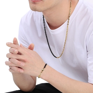 Detailed view of bicolor black and gold bamboo chain necklace and bracelet on model