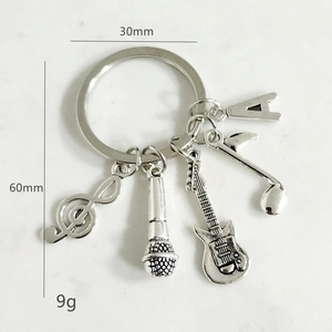 Detailed view of silver music keychain with guitar, microphone, and note charms