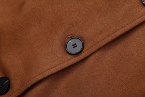 Vue macro du tissu en daim marron et des boutons noirs sur la veste vintage