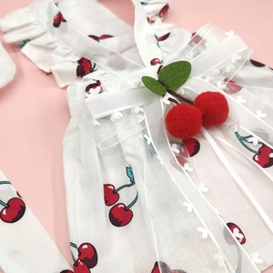 Detail of pet dress with red cherry prints and double-layered organza bow decoration