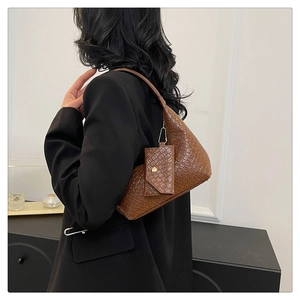 Brown woven texture handbag with matching coin purse accessory shown on shoulder
