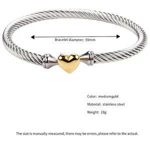 Women's stainless steel cable heart bracelet with gold accents on a minimalist open bangle
