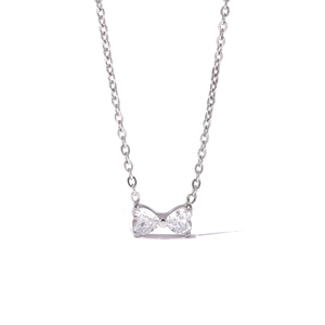 Collier élégant avec pendentif nœud argenté et zircons sur un fond blanc épuré