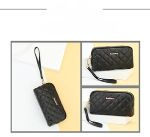 Detailed view of black quilted clutch bag with wrist strap and dual zippers