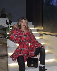 Detail of red plaid skirt set showing layered ruffles and textured bubble sleeve fabric