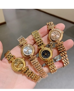 Close-up of four luxury gold quartz watches with roman numerals and metallic straps
