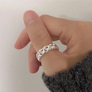 Dettaglio macro dell'anello intrecciato in argento sterling S925 sul pollice