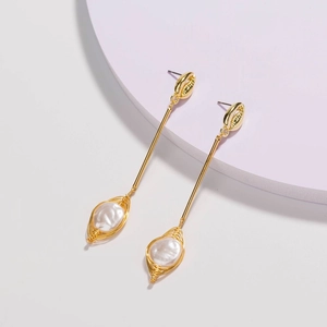 Elegant gold shell drop earrings with handmade wire-wrapped pearls on purple background