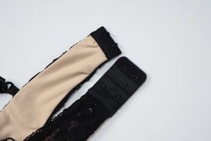 Makroaufnahme des dreireihigen Zwei-Haken-Verschlusses am schwarzen Spitzenkleid