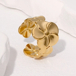 Minimalistischer vergoldeter Edelstahl-Blumenring mit offenem Design auf weißem Stein