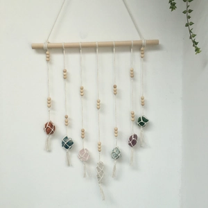 Macro detail of Bohemian hand-woven tassels with seven natural chakra stones and wood beads