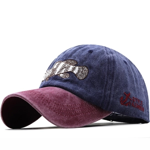 Close-up of embroidered shark and anchor details on a washed cotton baseball cap