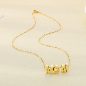 Close-up of golden MOM heart pendant necklace with opal on a textured beige background