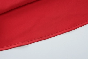 Detail shot of the red mesh dress hem showing professional stitching and smooth polyester fabric