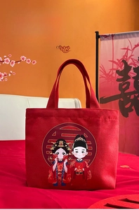 Detail of red wedding canvas tote bag with cartoon bride and groom and gold Xi character