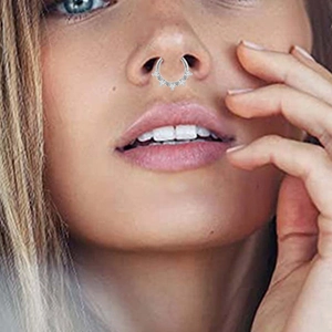 Close-up of nose ring with five triangular zircons on model for piercing display
